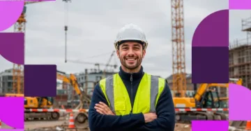 Engenheiro civil sorrindo de braços cruzados em um canteiro de obras. Ele usa capacete branco e colete reflexivo amarelo. Ao fundo, guindastes e tratores em uma construção desfocada, com grafismos roxos da marca Sólides nas laterais.